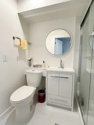 a bathroom with a toilet and a sink and a mirror at Beautiful place with Kitchen, Washing Machine, Internet near UBC, beach and DT in Vancouver