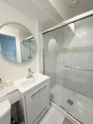a bathroom with a shower and a sink and a mirror at Beautiful place with Kitchen, Washing Machine, Internet near UBC, beach and DT in Vancouver