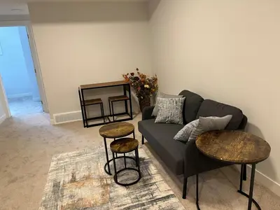 a living room with a couch and two tables at Modern & Stylish Private Suite in Pine Creek in Calgary
