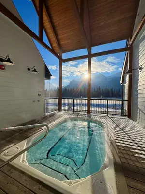 a hot tub on the deck of a house at Mountain View New Luxury Condo at Banff Entrance in Canmore