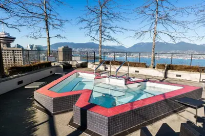 a pool on top of a building with a view of the water at Luxury Central Apartment with City Views in Vancouver