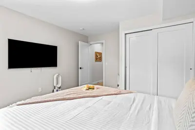 a bedroom with a bed with a tv on the wall at Charming 2BR Haven in Canmore Near DT and Banff in Canmore