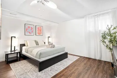 a white bedroom with a bed and a window at 1 Bedroom Cozy Retreat - Queen Bed, Pet Friendly, Smart TV, Secure & Private Access, Free Parking, Netflix & More! in Calgary