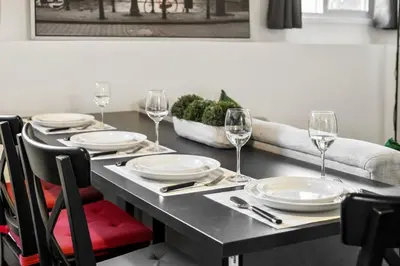 a dining room table with plates and wine glasses at 1 Bedroom Cozy Retreat - Queen Bed, Pet Friendly, Smart TV, Secure & Private Access, Free Parking, Netflix & More! in Calgary