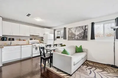 a kitchen and living room with a couch and a table at 1 Bedroom Cozy Retreat - Queen Bed, Pet Friendly, Smart TV, Secure & Private Access, Free Parking, Netflix & More! in Calgary