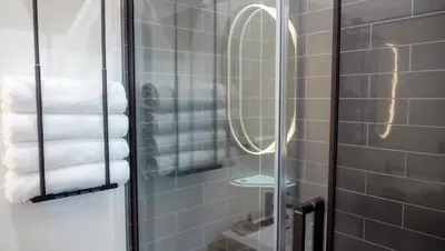 a shower with a glass door with towels in a bathroom at Skyridge Glamping in Kananaskis Village