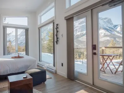 a bedroom with a bed and views of mountains at Skyridge Glamping in Kananaskis Village