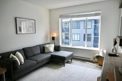 a living room with a couch and a window at Stylish 2-Bedroom Condo - Premium Comfort, Central Location in Surrey