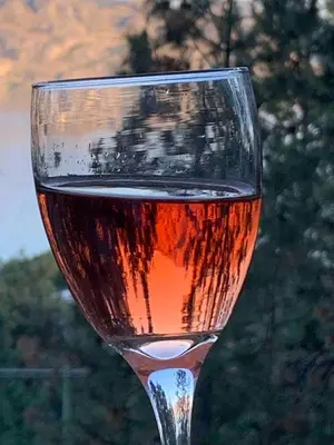 a glass of wine sitting on top of a table at Desert Pines Holiday Getaway in Peachland