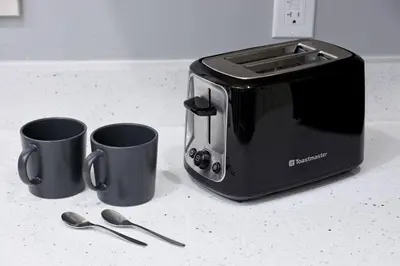 a toaster on a counter with two cups and spoons at Spacious 4BR Retreat near YVR and DT in Vancouver