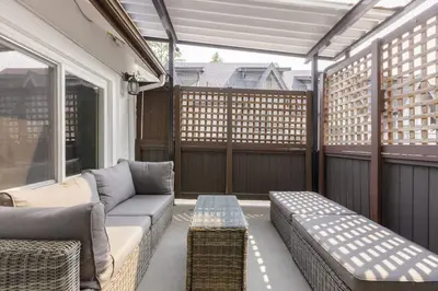 a screened in porch with a couch and a table at Spacious 4BR Retreat near YVR and DT in Vancouver