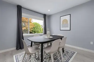 a dining room with a table and chairs and a window at Spacious 4BR Retreat near YVR and DT in Vancouver