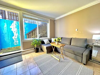 a living room with a couch and a table at Lovely 2BR BSMT Suite w Parking for Pickup in North Vancouver