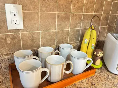a tray with four coffee mugs on a counter at Lovely 2BR BSMT Suite w Parking for Pickup in North Vancouver