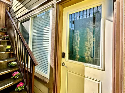 a door to a house with flowers on the stairs at Lovely 2BR BSMT Suite w Parking for Pickup in North Vancouver