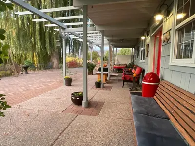 a patio with a wooden bench on a house at Blackbird Glen Bed and Breakfast, Glenmore, Kelowna, BC in Kelowna