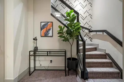 a staircase with a potted plant and a glass table at Rare Find, Double King Beds, Cozy and Vibrant in Calgary
