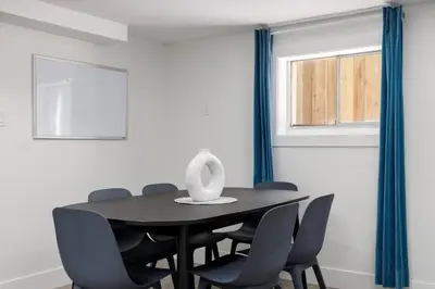 a dining room with a black table and chairs at Cozy BSMT suite Near UBC, Kits, and DT Vancouver in Vancouver