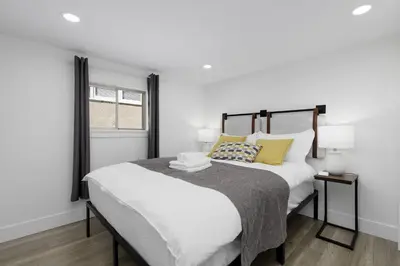 a bedroom with a large white bed with yellow pillows at Cozy BSMT suite Near UBC, Kits, and DT Vancouver in Vancouver