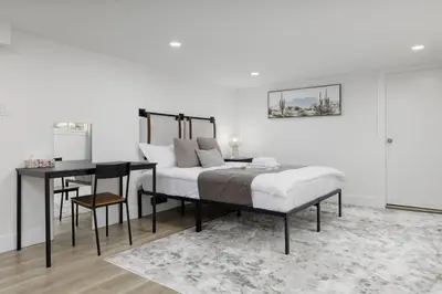 a bedroom with a bed and a table and a desk at Cozy BSMT suite Near UBC, Kits, and DT Vancouver in Vancouver