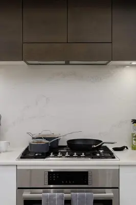 a kitchen with a stove with pots and pans on it at Luxury home near DT and YVR w 2 indoor parking in Vancouver