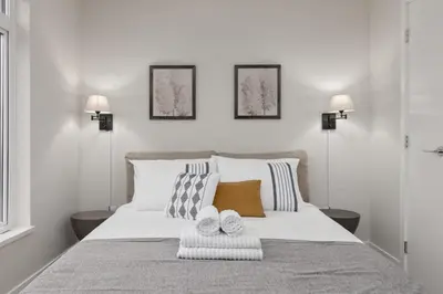 a bedroom with a bed with two towels on it at Luxury home near DT and YVR w 2 indoor parking in Vancouver