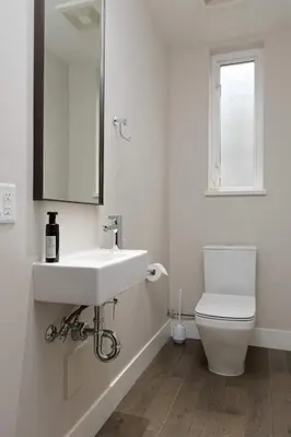 a white bathroom with a sink and a toilet at Luxury home near DT and YVR w 2 indoor parking in Vancouver