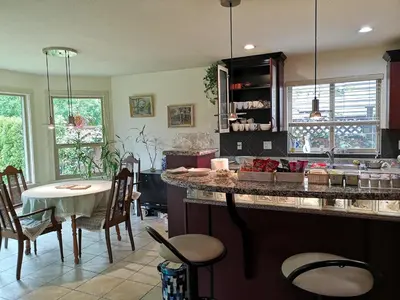 a kitchen with a counter and a table and chairs at Meadow Ridge Haven in Maple Ridge District Municipality