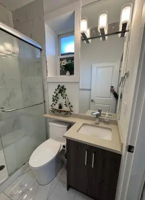 a bathroom with a toilet and a sink and a shower at Sweet home 2 bedroom suite in Surrey