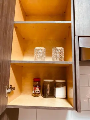 a cupboard with jars and glasses in it at Sweet home 2 bedroom suite in Surrey