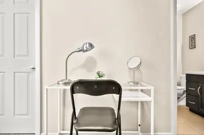 a white desk with a chair and a lamp at The Urban Peak on the 19th Floor of the Alura in Calgary