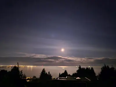 a full moon rising over the water at night at HOV B&B House -Hospitality Ocean View Victoria- in Victoria