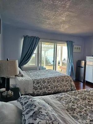 a bedroom with two beds and a large window at HOV B&B House -Hospitality Ocean View Victoria- in Victoria