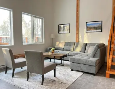 a living room with a couch and a table and chairs at Valley Edge Lodge in Golden