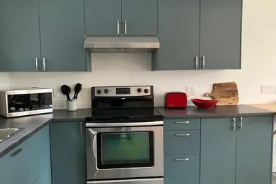 a kitchen with blue cabinets and a stove top oven at Valley Edge Lodge in Golden