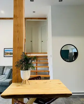a living room with a table and a mirror at Valley Edge Lodge in Golden