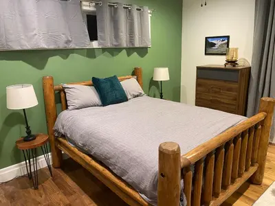 a wooden bed in a bedroom with green walls at Bluesky Lodge in Golden