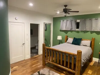a bedroom with a bed and a green wall at Bluesky Lodge in Golden