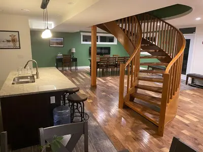 a kitchen and living room with a wooden spiral staircase at Bluesky Lodge in Golden