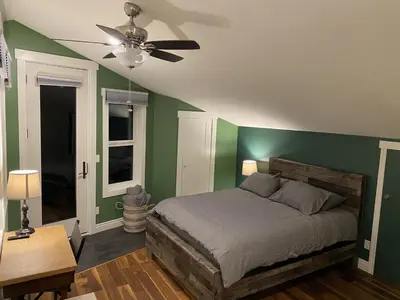 a bedroom with green walls and a bed with a ceiling fan at Bluebird Nest in Golden