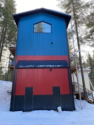 a blue and red building in the snow at Birch Suite in Golden