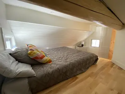 a bed in a bedroom with a wooden floor at Alder House in Golden