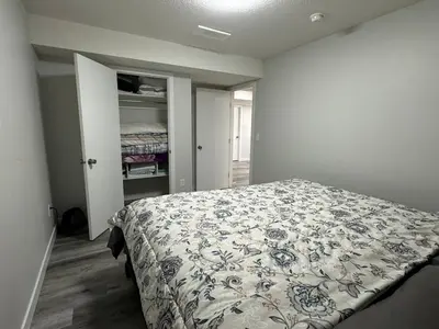 a bedroom with a bed with a blue and white comforter at HansBnB near Airport in Calgary