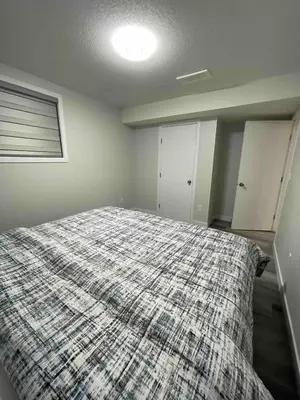 a bedroom with a large bed with a blanket at HansBnB near Airport in Calgary