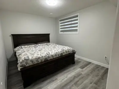 a bedroom with a bed and a window at HansBnB near Airport in Calgary