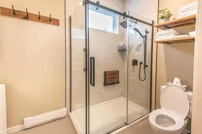a bathroom with a shower and a toilet at Sparkling NEW Rossland Midtown Studio Apartment in Rossland