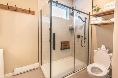 a bathroom with a shower and a toilet at Sparkling NEW Rossland Midtown Studio Apartment in Rossland