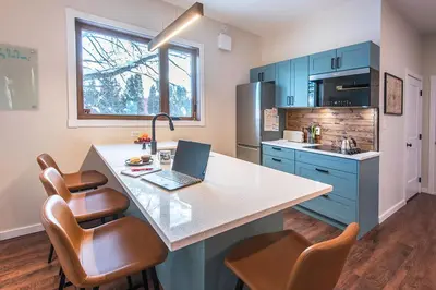 a kitchen with a desk with a laptop on it at Sparkling NEW Rossland Midtown Studio Apartment in Rossland