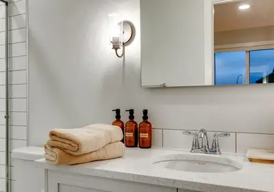a bathroom with a sink and two bottles of alcohol at Neutral Living 6Beds 4Bedrooms and Bonus Room Free Parking in Calgary