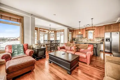 a living room with two couches and a kitchen at Southpoint 25 Two Bdrm Ski In Out w Hot Tub in Big White